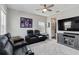 Living room featuring black leather reclining seats, a ceiling fan, and a TV at 9061 Luna Ln, Sarasota, FL 34241