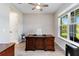 Bright home office with wooden desk, ceiling fan, and ample natural light at 9061 Luna Ln, Sarasota, FL 34241