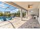 Covered outdoor patio with a pool, fan, and built in outdoor grill at 9061 Luna Ln, Sarasota, FL 34241