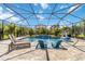 Stunning screened-in pool with waterfall feature, lounge chairs, and lush landscaping, perfect for relaxation at 9061 Luna Ln, Sarasota, FL 34241