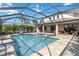 Enjoy outdoor living with this screened-in pool, patio kitchen, and lounge area at 9061 Luna Ln, Sarasota, FL 34241