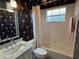 A full bathroom with black wallpaper with jellyfish, a tiled shower and a tub at 3724 71St E Ter, Sarasota, FL 34243