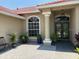 Inviting front entrance featuring a decorative door, lush plants, and a stylish light fixture at 3724 71St E Ter, Sarasota, FL 34243