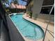 Backyard pool with a playful beach ball is surrounded by a screened enclosure, patio and privacy hedges at 3724 71St E Ter, Sarasota, FL 34243