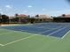 Outdoor tennis court with green and blue surface and shaded seating area near surrounding homes at 3724 71St E Ter, Sarasota, FL 34243