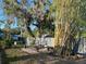 This backyard has mature trees, privacy fencing, a seating area, and a place for enjoying time outside at 1010 Gun Club Rd, Sarasota, FL 34232