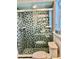 Bathroom featuring a glass shower with decorative blue tile and a toilet at 1010 Gun Club Rd, Sarasota, FL 34232