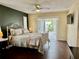 This main bedroom features an ornamental metal frame bed and french doors to the pool at 1010 Gun Club Rd, Sarasota, FL 34232
