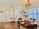 Dining room featuring hardwood floors, a stylish chandelier, and an abundance of seating for guests at 1010 Gun Club Rd, Sarasota, FL 34232