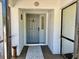 Inviting foyer with a grey front door with sidelight and a screened entrance at 1010 Gun Club Rd, Sarasota, FL 34232