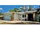 Charming single-story home featuring stone accents, a metal roof and a cozy front patio area at 1010 Gun Club Rd, Sarasota, FL 34232