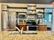 Kitchen highlighting stainless steel appliances, custom shelving, granite countertops and pass through to bedroom at 1010 Gun Club Rd, Sarasota, FL 34232