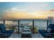 Serene balcony view with outdoor seating overlooking a marina filled with boats, set against a colorful sunset backdrop at 1155 N Gulfstream Ave # 706, Sarasota, FL 34236
