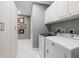 Laundry room with washer, dryer, white cabinets, and shelving at 1155 N Gulfstream Ave # 706, Sarasota, FL 34236