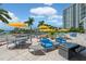 Outdoor patio area featuring comfortable seating, dining sets, and a community pool surrounded by lush landscaping at 1155 N Gulfstream Ave # 706, Sarasota, FL 34236