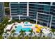 Aerial view of the pool deck featuring a pool, hot tub, cabanas and palm trees at 1155 N Gulfstream Ave # 706, Sarasota, FL 34236