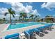 Beautiful pool area with comfortable lounge chairs and clear blue water surrounded by palm trees under a sunny sky at 1155 N Gulfstream Ave # 706, Sarasota, FL 34236