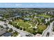 An aerial view of a park featuring sports courts, playgrounds, and green spaces surrounded by residential areas at 11707 Gramercy Park Ave, Bradenton, FL 34211