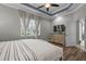 Spacious bedroom with tray ceiling, large windows, and a dresser beneath a wall-mounted television at 11707 Gramercy Park Ave, Bradenton, FL 34211
