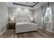 This bedroom features a beautiful tufted bed frame, wood floors, and three lovely windows at 11707 Gramercy Park Ave, Bradenton, FL 34211