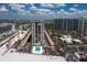 Aerial view of a beachfront condo complex with a pool, tennis courts, and lush landscaping at 1212 Benjamin Franklin Dr # 901, Sarasota, FL 34236