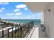Balcony view of a white sandy beach, blue ocean, and a black iron railing with chairs at 1212 Benjamin Franklin Dr # 901, Sarasota, FL 34236