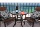 Table for two on balcony with wine and chairs overlooking a beautiful view of the ocean at 1212 Benjamin Franklin Dr # 901, Sarasota, FL 34236