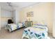 Bright bedroom features two twin beds, yellow walls, and built-in cabinetry with a ceiling fan at 1212 Benjamin Franklin Dr # 901, Sarasota, FL 34236
