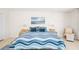 Bright bedroom with a blue and white quilt, blue throw pillows, and a decorative ocean painting at 1212 Benjamin Franklin Dr # 901, Sarasota, FL 34236
