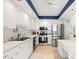 Well-lit kitchen with stainless steel appliances, sleek white cabinets, and a tile floor at 1212 Benjamin Franklin Dr # 901, Sarasota, FL 34236