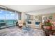 Well-lit living room with a seating area, balcony access, and ocean views at 1212 Benjamin Franklin Dr # 901, Sarasota, FL 34236