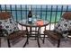 Outdoor view with table, two chairs, beverage and ocean backdrop at 1212 Benjamin Franklin Dr # 901, Sarasota, FL 34236