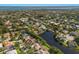 A captivating aerial view showcases a neighborhood with verdant trees and a tranquil lake reflecting the sky above at 1217 92Nd Nw St, Bradenton, FL 34209