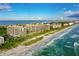 Stunning aerial view of beachfront condos along a pristine shoreline with blue water at 1281 Gulf Of Mexico Dr # 906, Longboat Key, FL 34228