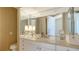 Bright bathroom with a mirrored wall, a granite countertop, and vanity storage at 1281 Gulf Of Mexico Dr # 906, Longboat Key, FL 34228