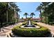 Exterior view showcasing a grand entrance with a fountain and palm tree lined drive at 1281 Gulf Of Mexico Dr # 906, Longboat Key, FL 34228