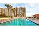 Large, inviting pool surrounded by tall palm trees, providing a relaxing vacation vibe at 1281 Gulf Of Mexico Dr # 906, Longboat Key, FL 34228