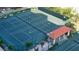 Aerial view of several well-maintained tennis courts, offering a premier recreational amenity surrounded by lush landscaping at 1281 Gulf Of Mexico Dr # 906, Longboat Key, FL 34228