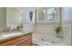 Close-up of bathroom featuring granite countertops, a luxurious soaking tub, and a window at 13625 3Rd Ne Ave, Bradenton, FL 34212