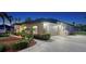 Home exterior featuring a spacious garage, manicured landscaping, and inviting curb appeal at twilight at 13625 3Rd Ne Ave, Bradenton, FL 34212