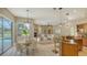 Open-concept kitchen, dining, and living area with ample natural light, fireplace, and backyard pool view at 13625 3Rd Ne Ave, Bradenton, FL 34212