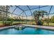 The enclosed lanai features a serene pool and integrated hot tub overlooking a lush backyard at 13625 3Rd Ne Ave, Bradenton, FL 34212