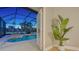 View through a door to an outdoor pool area surrounded by a screened enclosure at 13625 3Rd Ne Ave, Bradenton, FL 34212