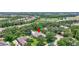 A high-angle view of a beautiful home with a pristine lawn, mature trees, and neighborhood with community amenities in the distance at 14104 E 22Nd Ter, Bradenton, FL 34212