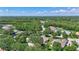 Aerial view of a lush neighborhood with large homes, mature trees, and a beautiful blue sky at 14104 E 22Nd Ter, Bradenton, FL 34212