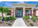 Beautiful home entrance featuring stone accents, a blue double door, and professionally landscaped foliage at 14104 E 22Nd Ter, Bradenton, FL 34212