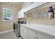 Well-organized laundry room with modern appliances, storage, and a window at 14104 E 22Nd Ter, Bradenton, FL 34212