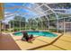 Inviting pool area with screened-in enclosure, sun loungers and clear blue skies at 14104 E 22Nd Ter, Bradenton, FL 34212