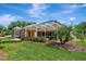 Home's screened lanai area features lush landscaping and a well-maintained lawn at 14104 E 22Nd Ter, Bradenton, FL 34212