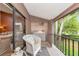 Balcony space with laundry closet, wicker chair, and tropical outdoor view at 1532 Pelican Point Dr # 240, Sarasota, FL 34231